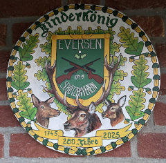 Kinderkönigs-Jubiläumsscheibe des Schützenvereins Eversen zum 280-jährigen Jubiläum mit Vereinswappen, Eichenlaub-Rand und drei Hirschmotiven vor Ziegelwand